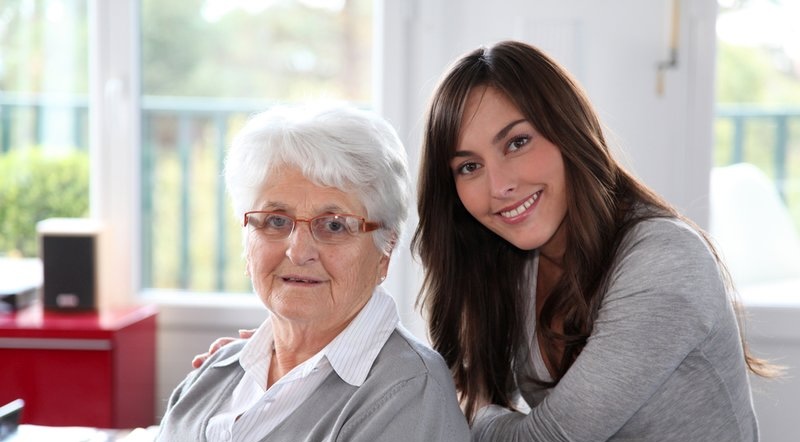 Carer supporting an elderly person with personalised care