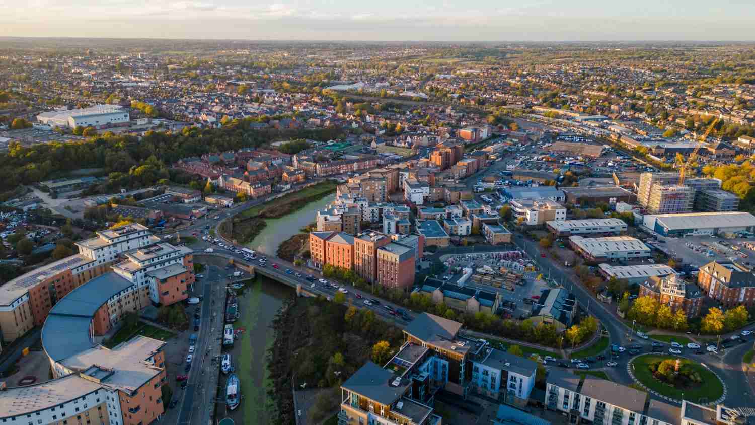 Overhead perspective of Colchester, highlighting the city's architecture, streets, and parks in a vibrant urban setting.