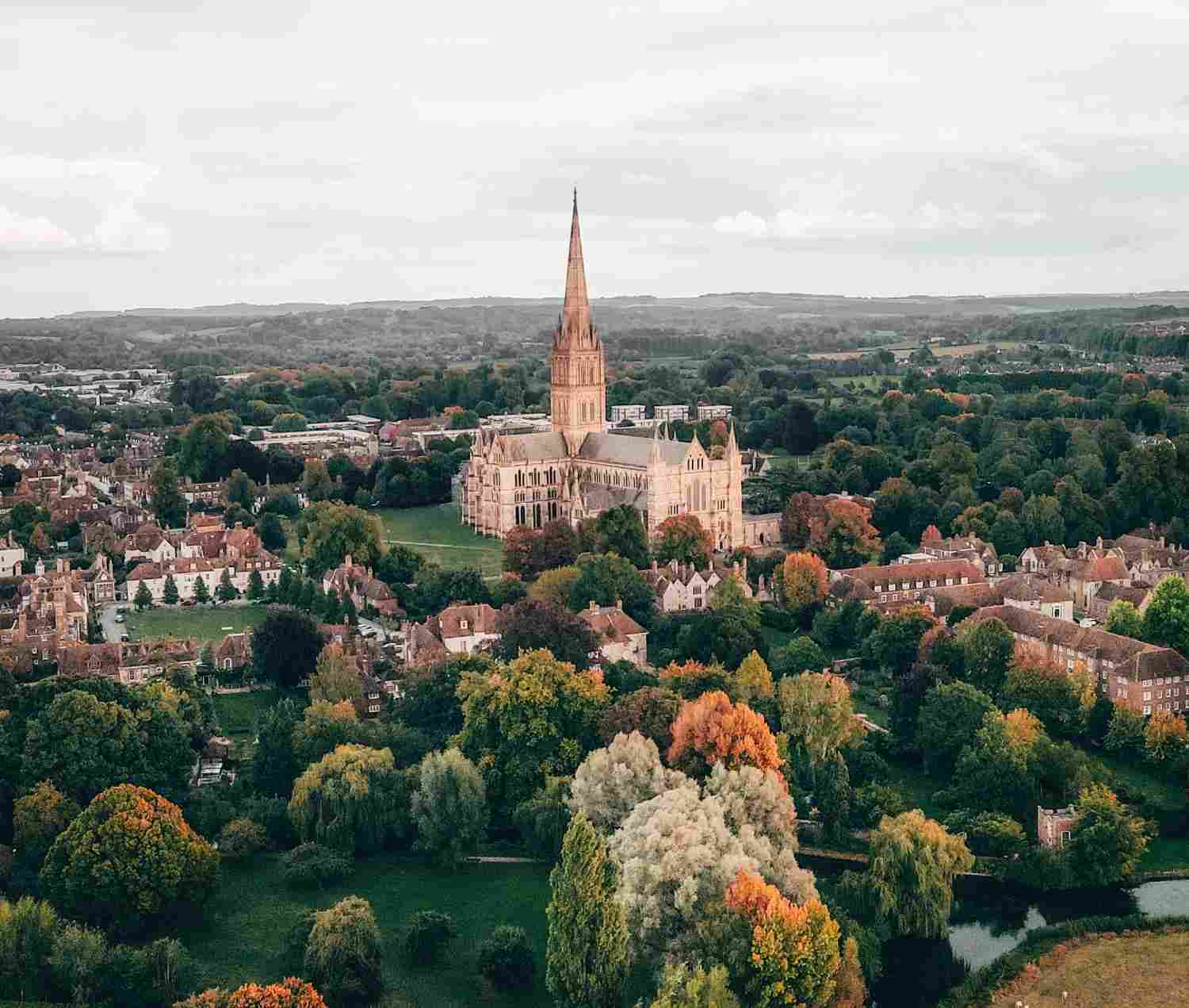 Aerial view of a town featuring a prominent church in the background amidst residential and commercial buildings.
