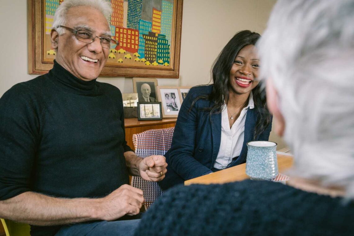Hometouch carer meeting an elderly man at home, both smiling during a relaxed conversation