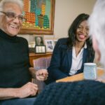 Hometouch carer meeting an elderly man at home, both smiling during a relaxed conversation